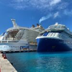 12 Big Differences Between Celebrity Cruises and Royal Caribbean Royal Caribbean and Celebrity cruise ships docked next to each other.