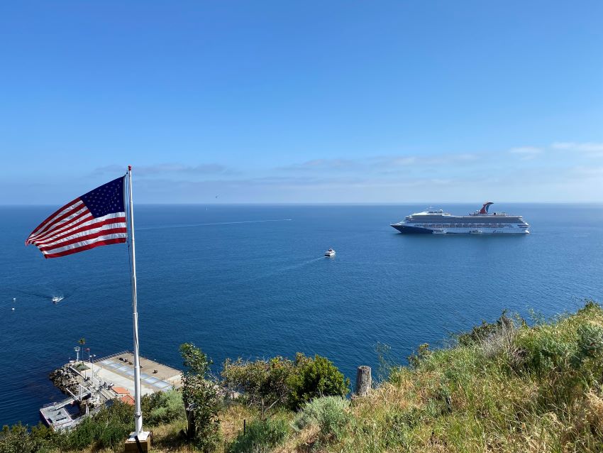 American flag flying next to a cruise ship