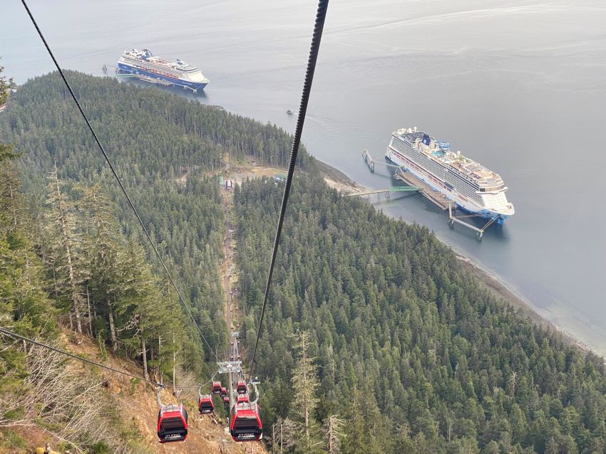 Red gondola going up side of mountain