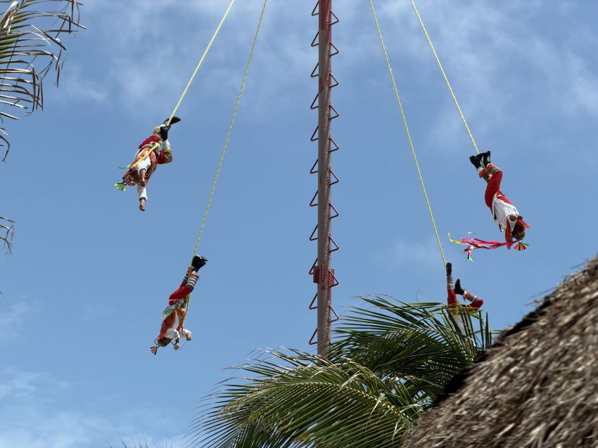 Men swinging from a tower in Costa Maya, Mexico